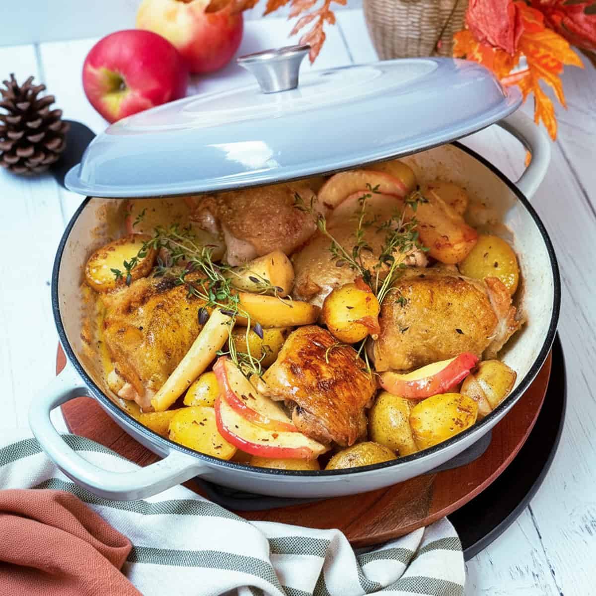 Baked Cider Braised Chicken with root vegetable and apple slices ready to serve.