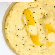 Pinterest image of garlic mashed potatoes topped with chives and the words, "Easy side and Garlic Mashed Potatoes"