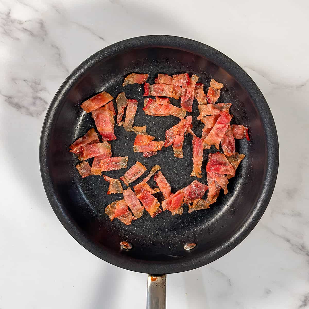 Cooking chopped bacon in a nonstick skillet.