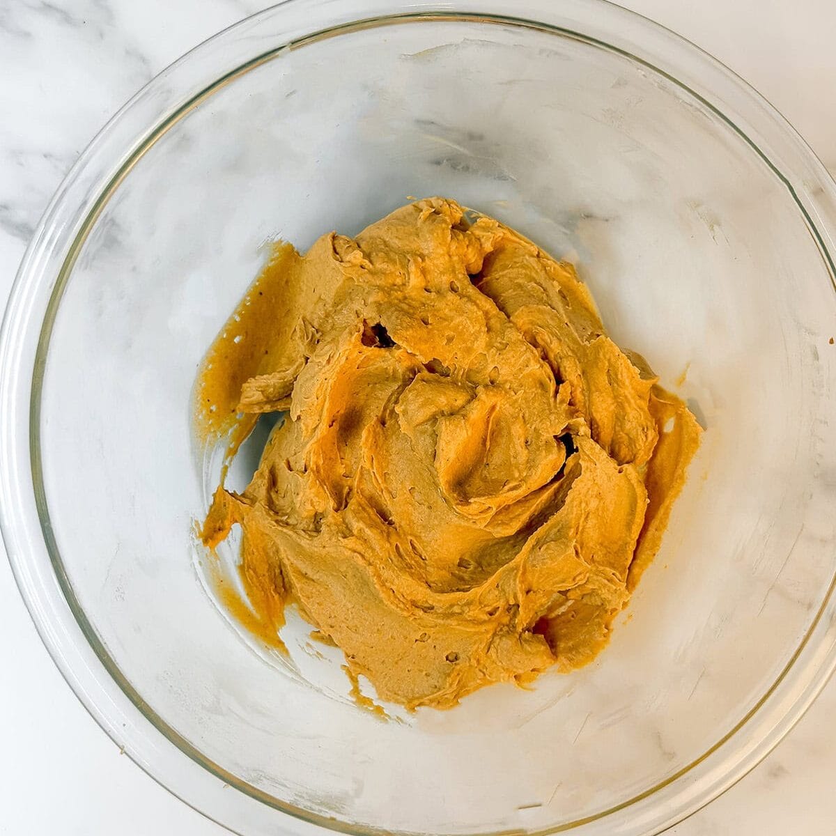 Pumpkin cream base in a glass bowl waiting to fold into the Chantilly cream filling.