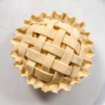 Square image of unbaked lattice topped pie with fluted edges.