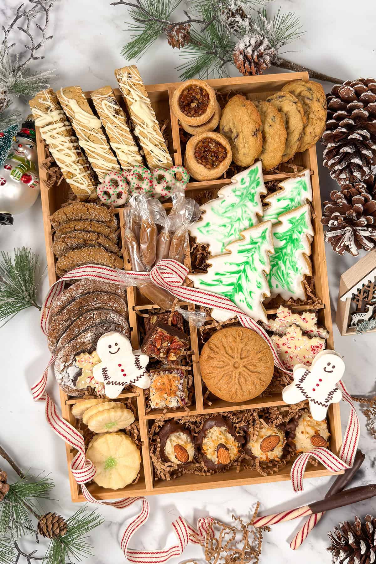 Top view of Woodland Christmas themed cookie box with 12 cookies from sugar cookies to molasses, pecan tassies, macaroons, and more.
