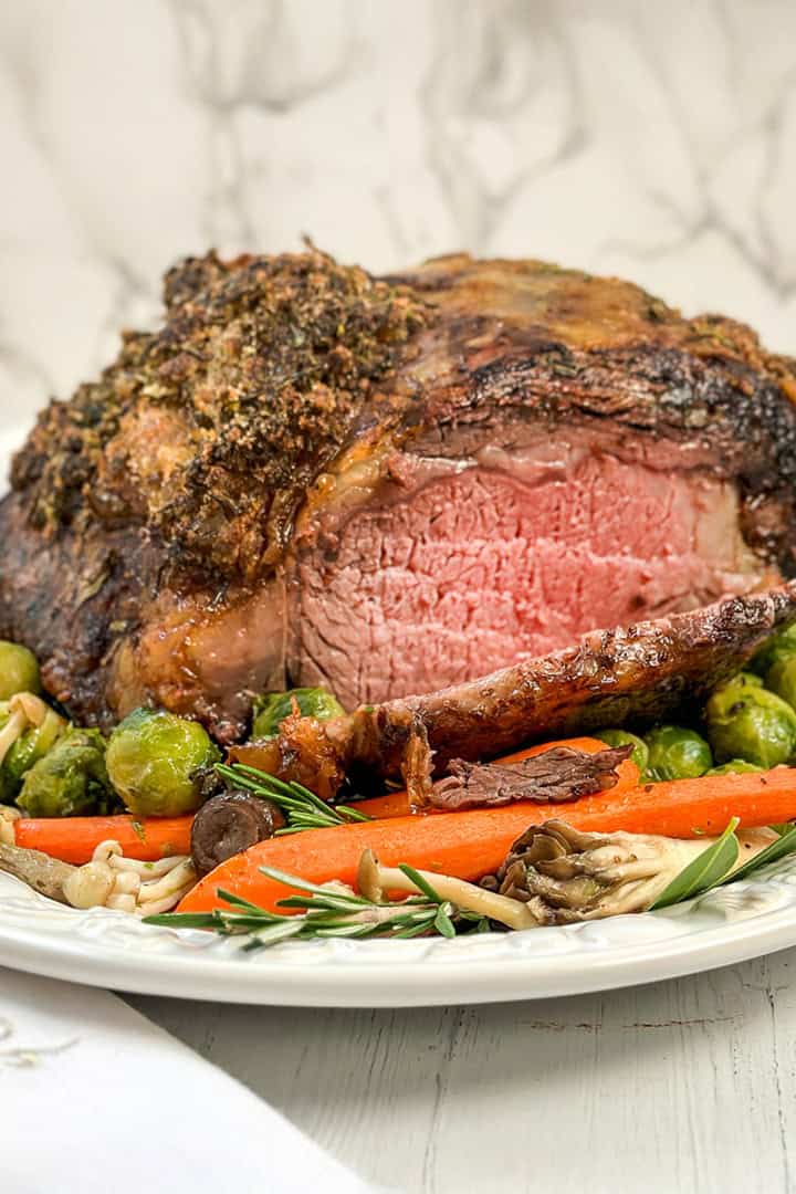 Square image of sliced prime rib roast resting on a serving platter for the holidays.