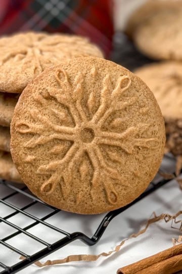 Close-up of a stamped snowflake speculoos cookie with crisp, caramelized edges, styled for holiday baking.
