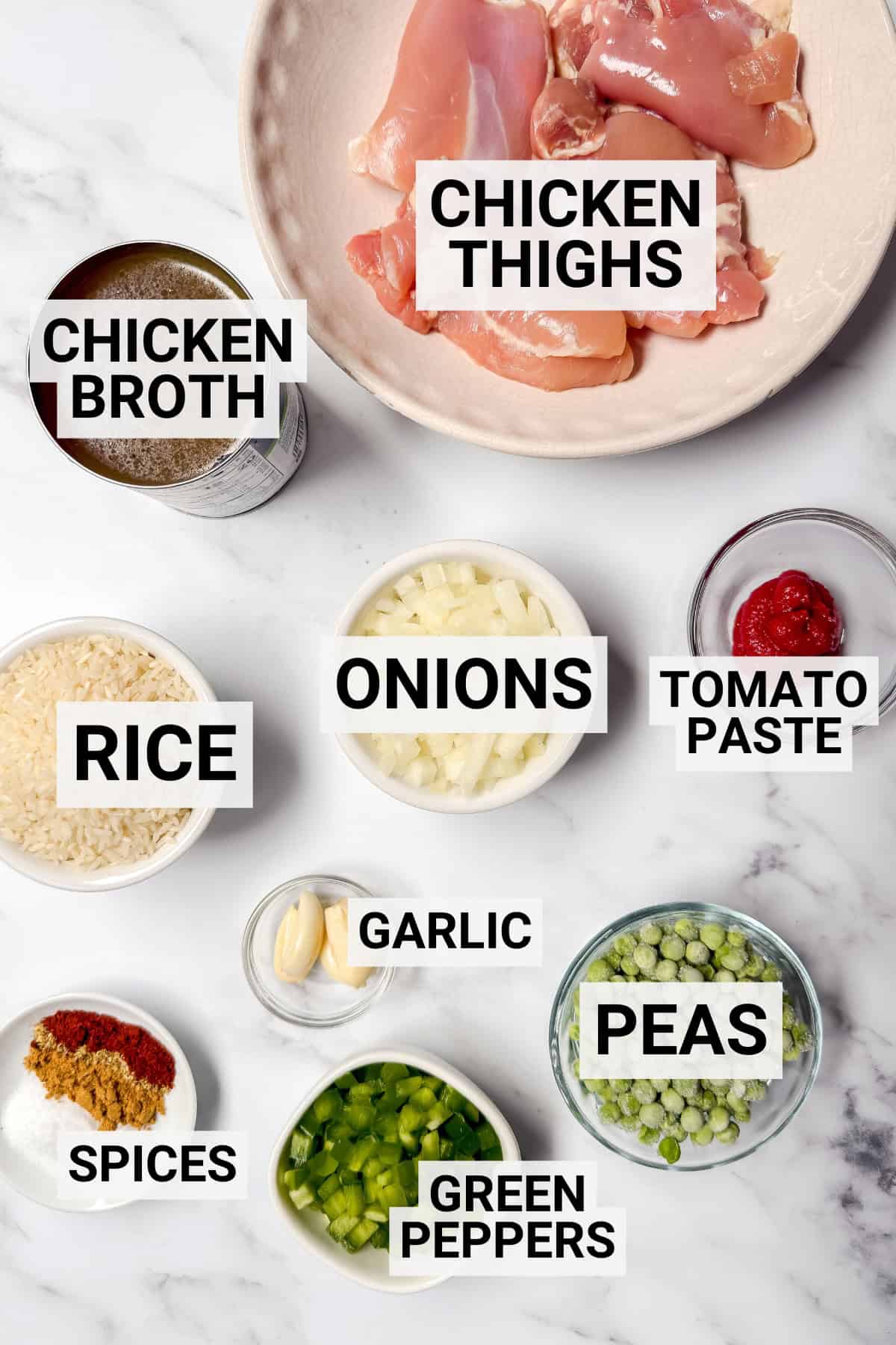 Ingredients for arroz con pollo including chicken thighs, rice, broth, onions, garlic, peppers, peas, and spices.