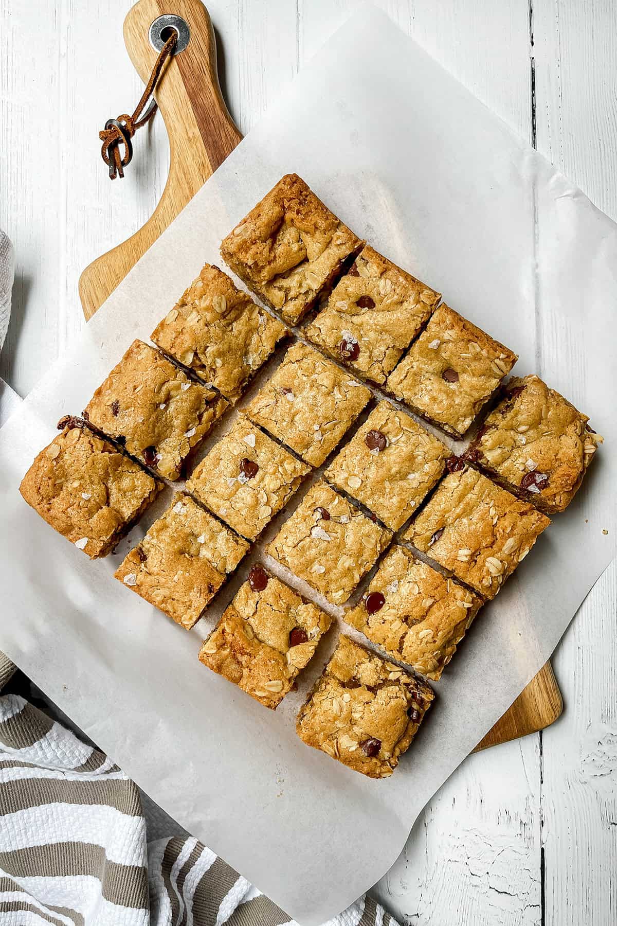 Oatmeal chocolate chip cookie bars cut into squares on parchment paper.