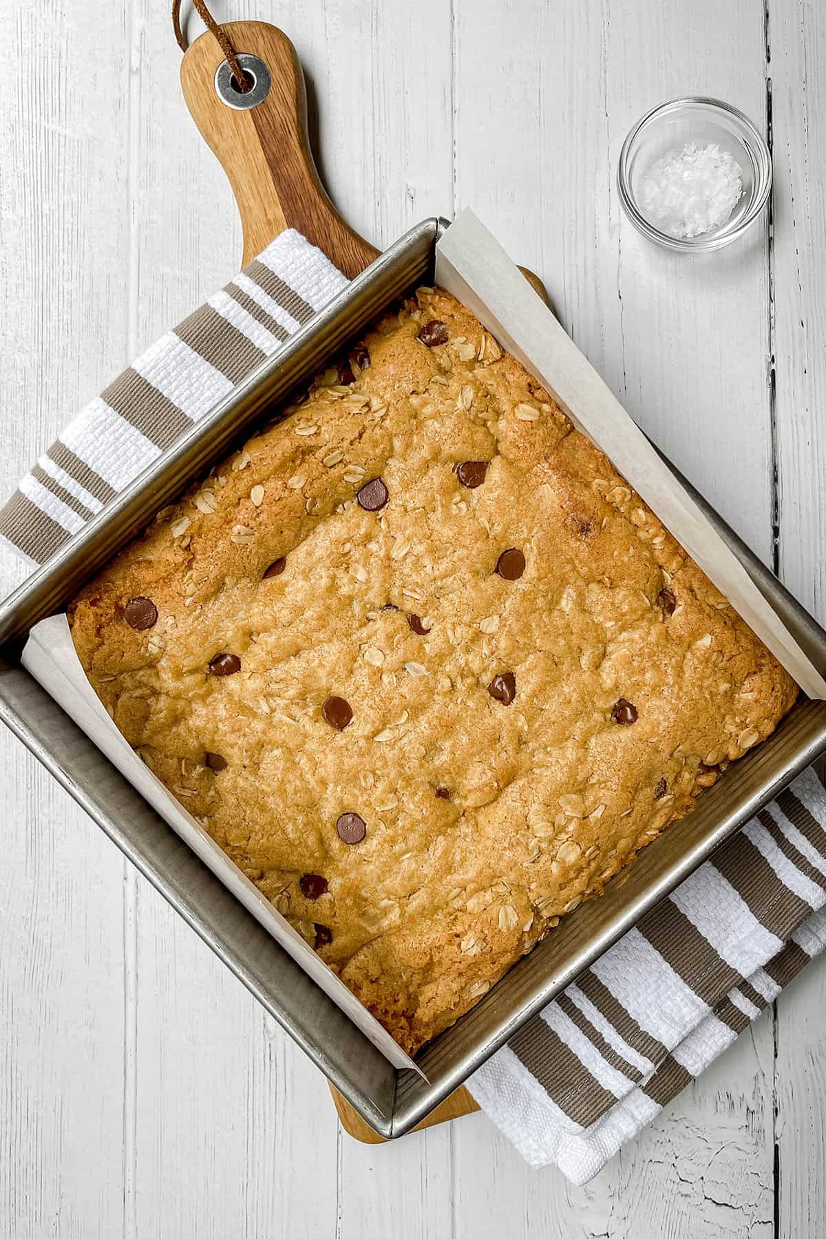 Baked oatmeal chocolate chip cookie bars in a square pan before slicing.