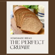 A close-up, high-angle view of a sliced loaf of 100% whole wheat bread on a rustic wooden board, showing a soft, even crumb and golden-brown crust.
