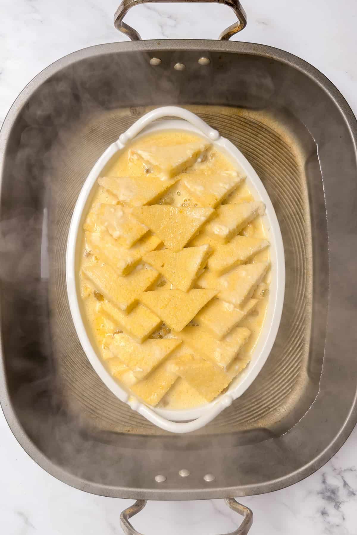 Bread and butter pudding placed in a hot water bath before baking in the oven.