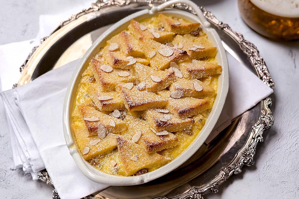 Baked bread and butter pudding with layered bread and custard in a ceramic baking dish.