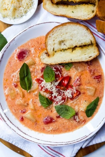 Homemade tomato potato soup served warm with bread and Parmesan.