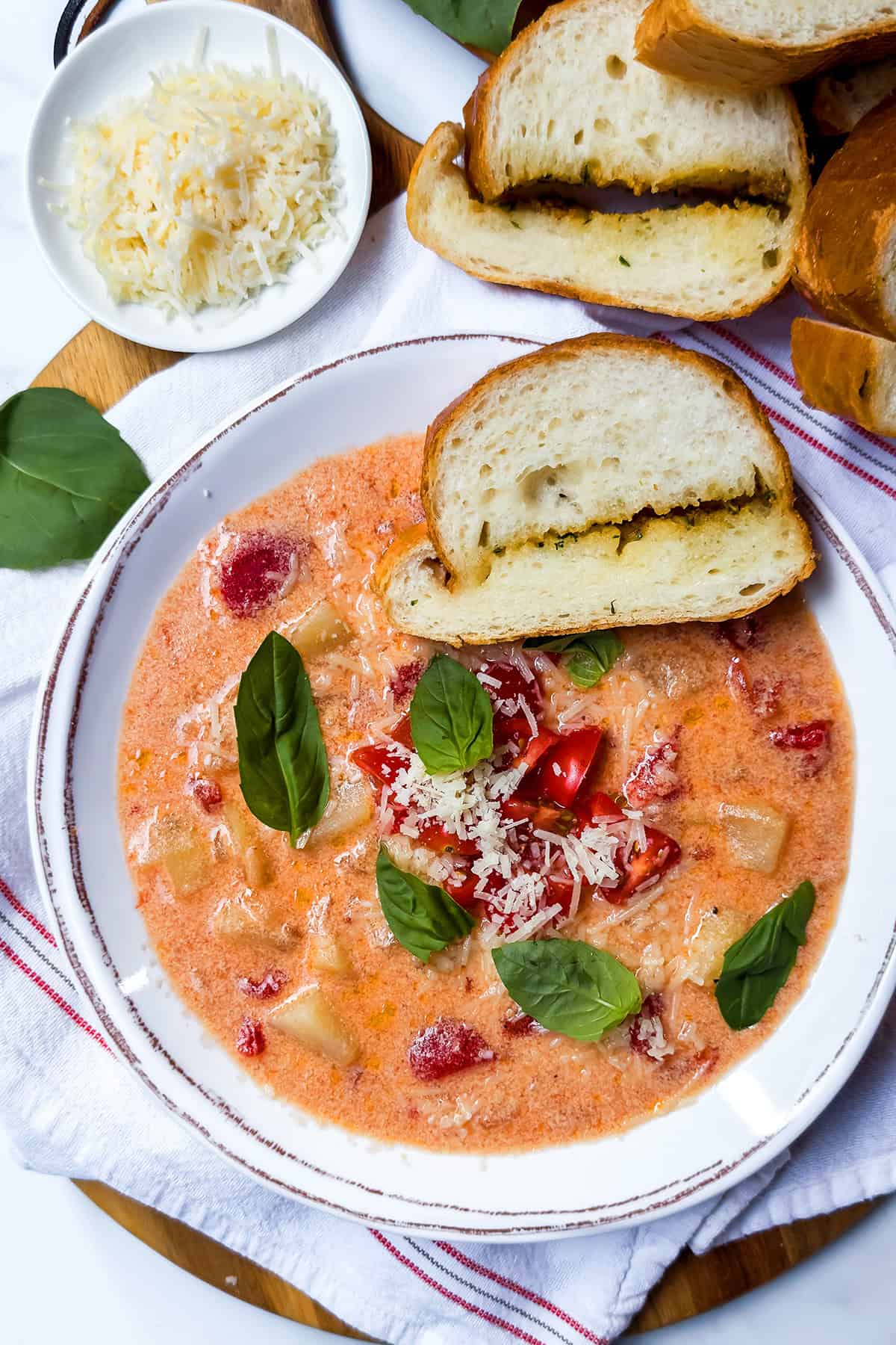 Old-fashioned tomato potato soup with basil, tomatoes, and grated Parmesan.