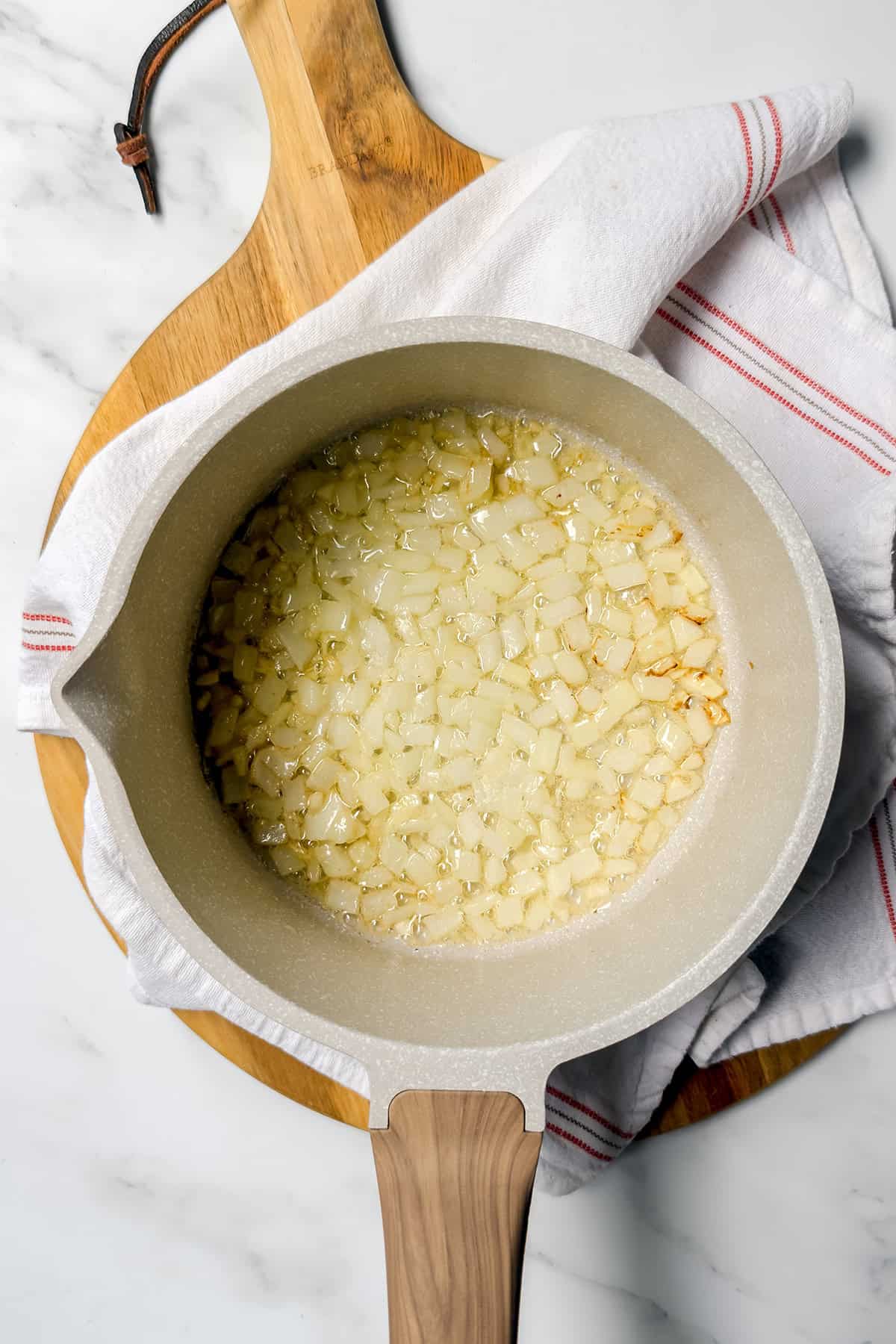 Chopped onions saut&eacute;ing in melted butter in a soup pot.