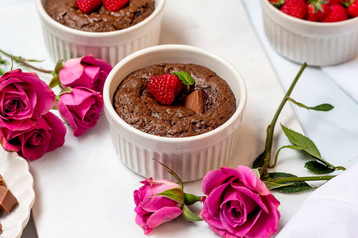 Warm mini chocolate cake with a molten-style center, garnished with raspberries.