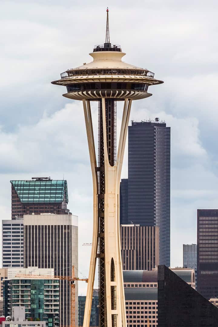 The Space Needle in Seattle stands prominently in front of several downtown skyscrapers under a cloudy sky, resembling the fresh start of a pantry reset amid the city's vibrant energy.