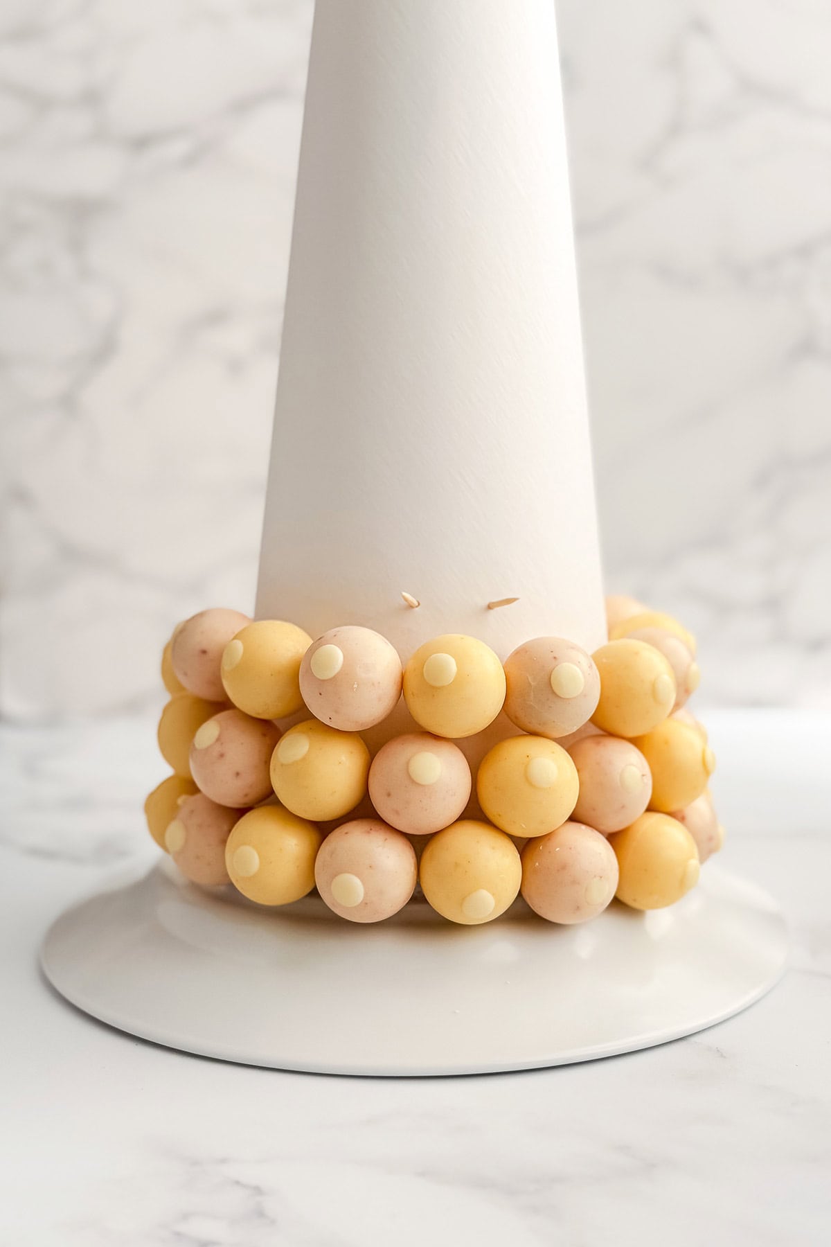 Toothpicks and wrapped truffles attached to the base of a bonbon tree cone.