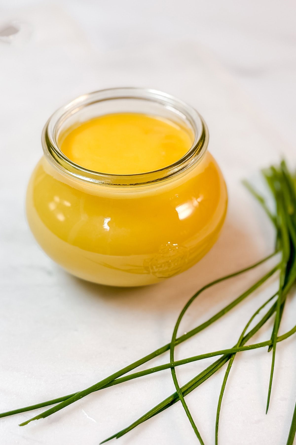 A small glass jar filled with classic hollandaise sauce ready for serving.
