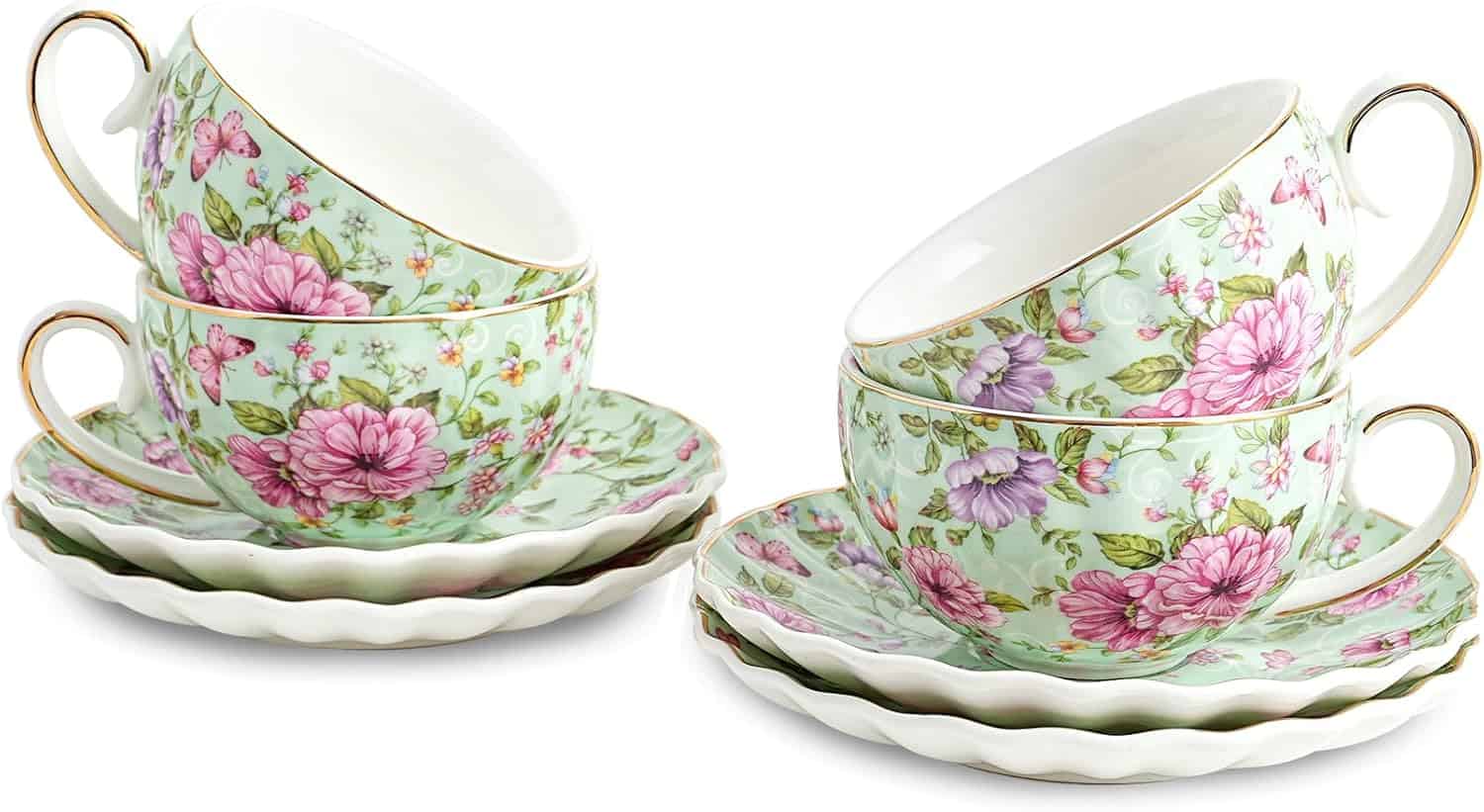 Four floral-patterned teacups with gold handles are stacked on matching saucers, featuring pink, purple, and green designs.