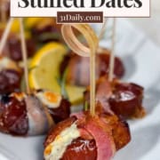 Close-up of stuffed dates wrapped in pancetta and filled with tangy blue cheese, served on a white plate with toothpicks and lemon slices. Text overlay reads "Blue Cheese Stuffed Dates" and "Easy Party Appetizer.