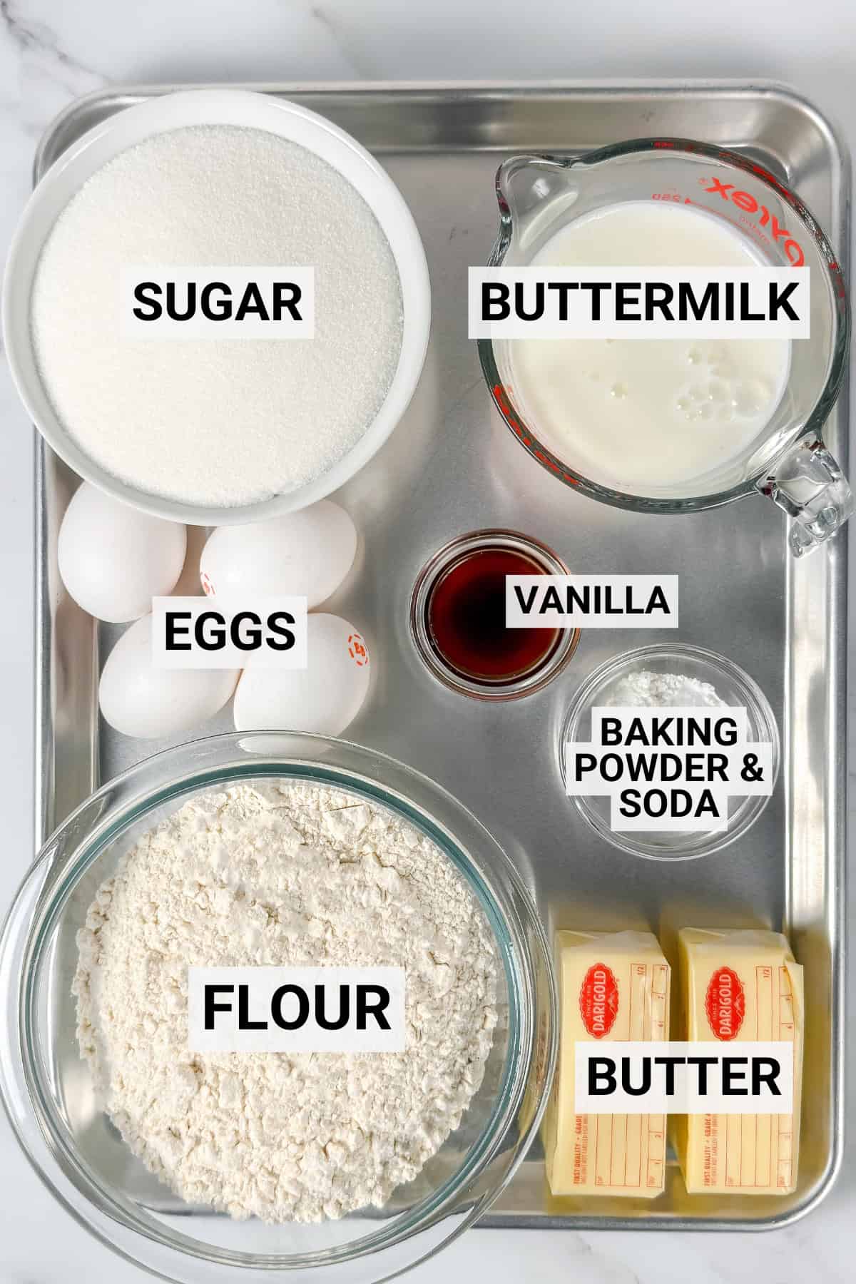 Tray with labeled bowls and containers holding sugar, eggs, flour, butter, buttermilk, vanilla extract, and baking powder & soda-everything you need to make a classic Kentucky Butter Cake.