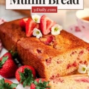 A loaf of healthy strawberry yogurt bread with fresh strawberries and flowers, sliced on a marble board. Text overlay reads “Healthy Strawberry Muffin Bread, Sweetened with Honey, Refined Sugar Free.”.