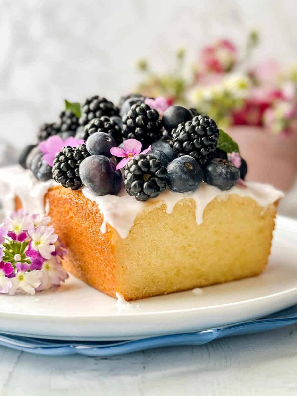 Side view of sliced pound cake recipe topped with blueberries and blackberries.