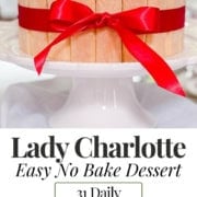A lady charlotte cake decorated with ladyfingers, whipped cream, and strawberries, tied with a red ribbon, displayed on a cake stand with two step-by-step assembly images below.