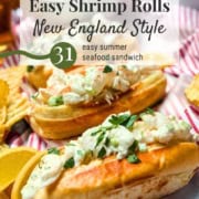 Two New England-style shrimp rolls topped with chopped herbs on a tray with potato chips and lemon wedges, alongside the text: "Easy Shrimp Rolls Recipe New England Style.