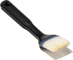 A black-handled silicone basting brush with white bristles is shown against a white background—perfect for preparing your favorite salad recipes.