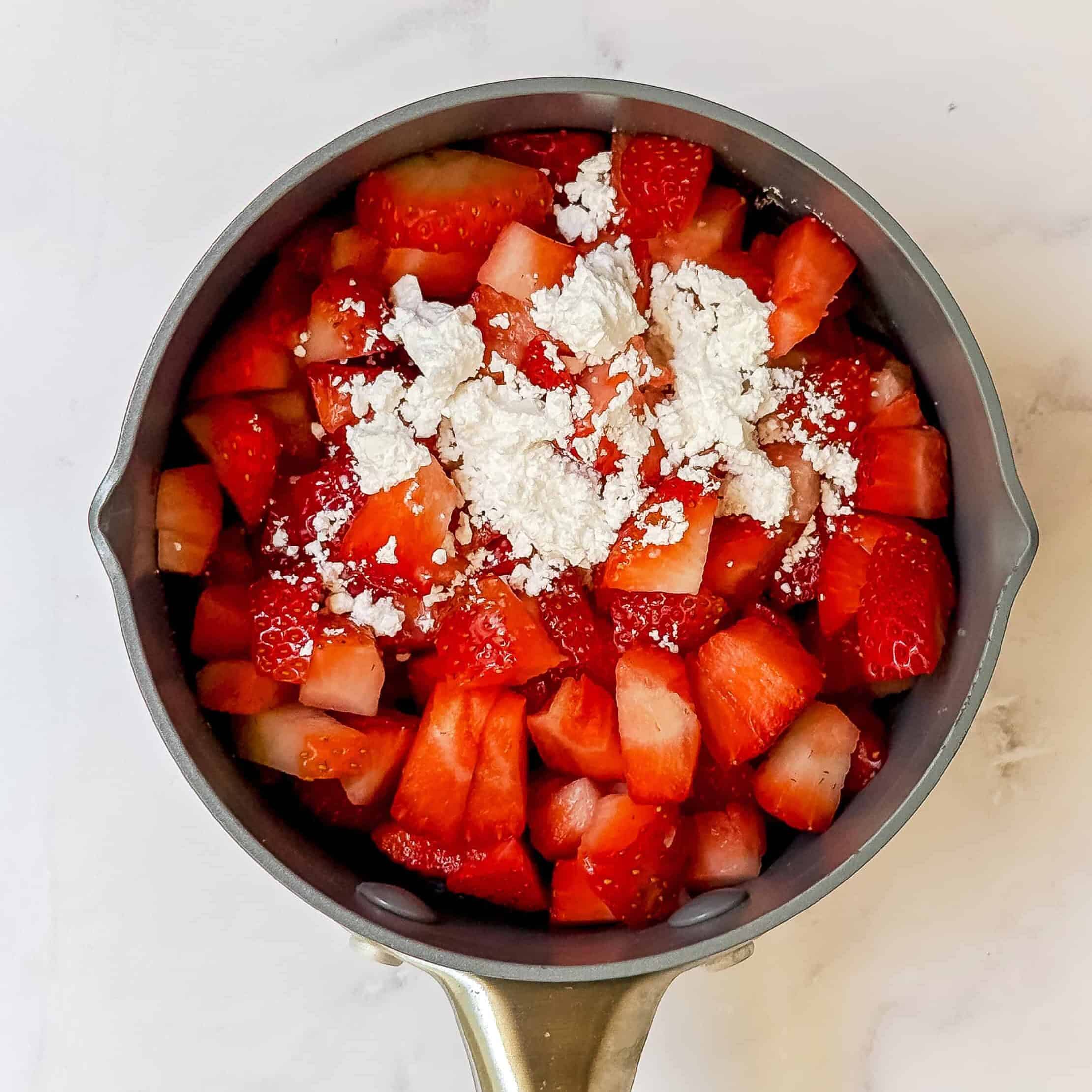 Chopped strawberries with powdered sugar and lemon, ready to become a fresh strawberry sauce for Lady Charlotte Cake.