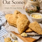A group of oat scones on parchment paper with a butter knife and butter, a teapot in the background, echoing the charm of a tea table. An inset photo shows sliced Colonial scones with butter on a plate.