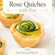 Mini Zucchini Quiches with feta are arranged on a white surface, each topped with a delicate spiral of zucchini, creating the look of elegant Rose Quiches. Text highlights their suitability for afternoon tea, brunch, and summer entertaining.