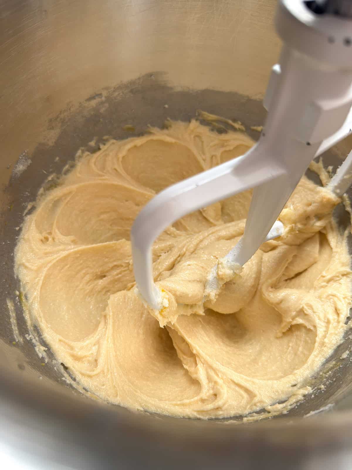 Mixing almond plum cake batter in a stand mixer until incorporated.