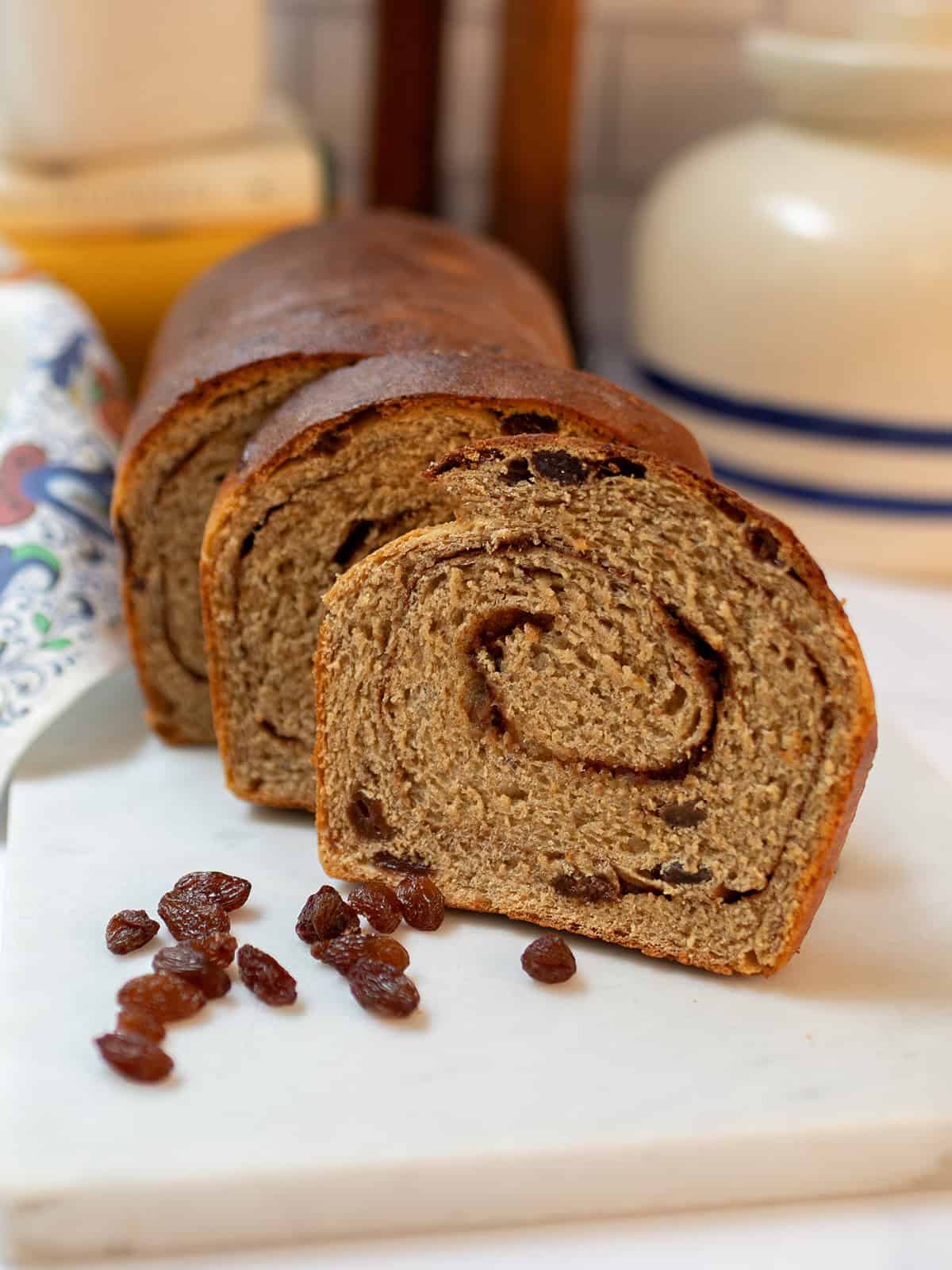 Whole wheat cinnamon raisin swirl bread sliced to show the cinnamon spiral and raisins.